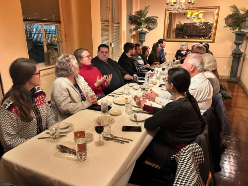 Keystone staff and spouses gathered around a table. In the foreground are Katharina and Katy, further in are Tracey, Brian, Marion and her husband, George, Lee and his wife, and John with his wife. Nancy is at the far end of the table.
