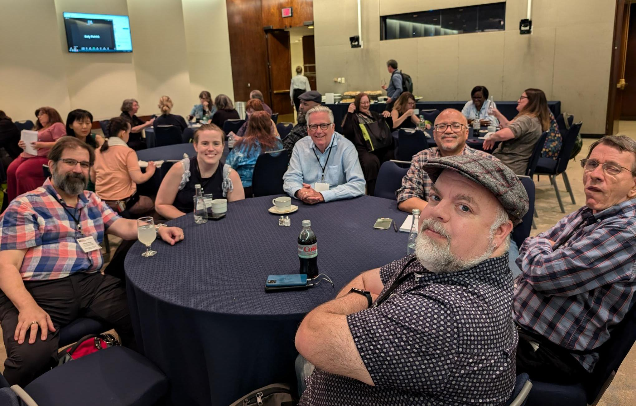 A number of KLAS Users sit at a round table covered in a black tablecloth. All are smiling and looking at the camera.