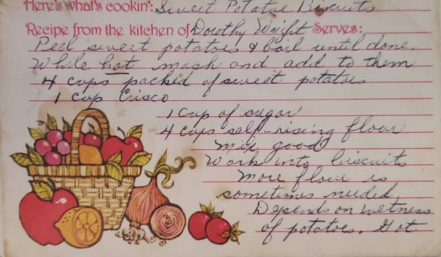 The sweet potato biscuit recipe card has labels for "Here's what's cookin'" and "From the kitchen of" in an imitation-handwriting font. The card has an image of various fruits and veggies spilling out of a basket in the lower corner.