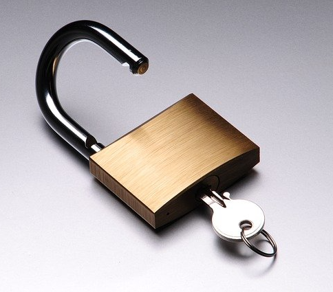 A key is inserted into an unlocked padlock.