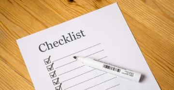 Stock photo of a paper checklist, with a pen at the ready to start marking off the lines.